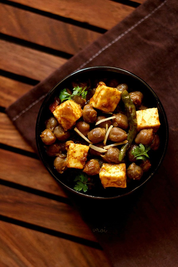 chole paneer served in a black bowl