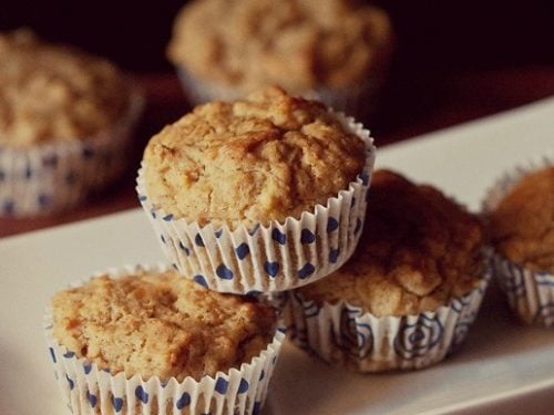 banana muffin placed on top of two banana muffins in a white tray