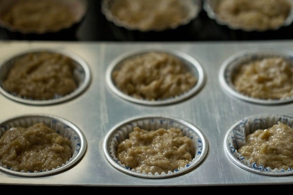 muffin batter in paper cups baking in muffin tin