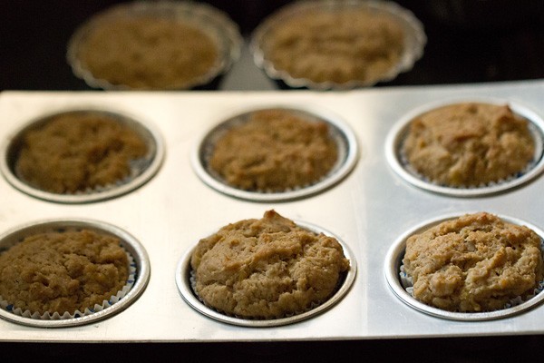 muffins baking in muffin tin in oven