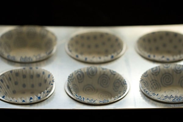 White and blue paper muffin liners set in muffin tin.