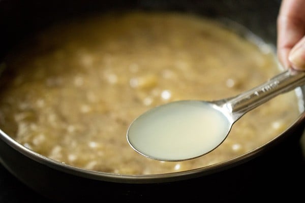 Closeup shot of lime juice in tablespoon measurer above banana muffin batter in bowl