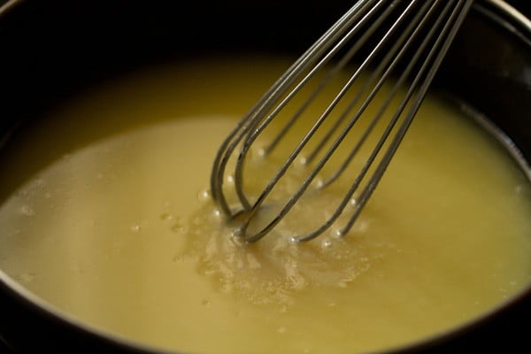 mixture being whisked with a balloon whisk