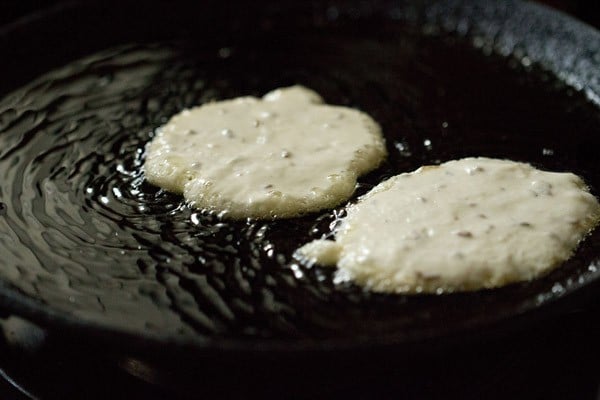 two malpua frying on pan