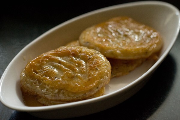 malpua rabdi in an oblong white serving bowl