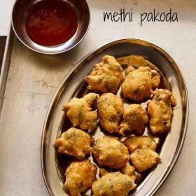 methi pakoda served on a plate with a side of chutney and text layover.