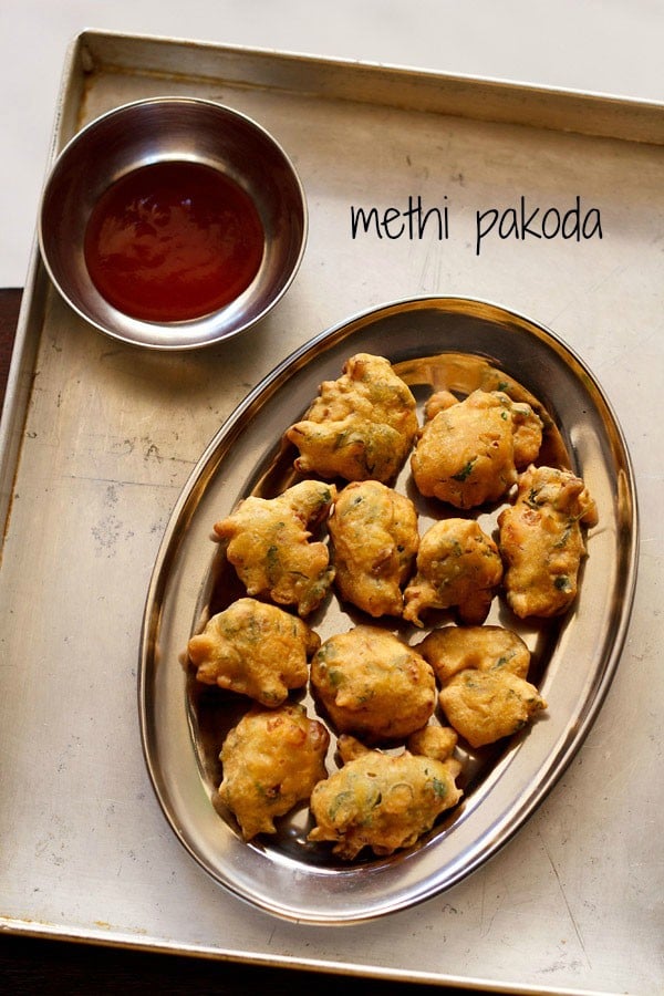 methi pakoda served on a plate with a side of chutney and text layover.