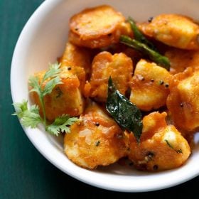 paneer 65 with a coriander sprig at right side in a white bowl.