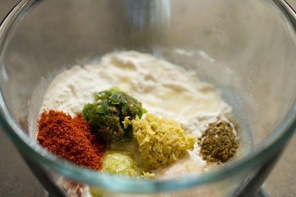 adding spices to the bowl with flour.