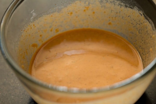 whisking the flour, spices, and water into a smooth batter.