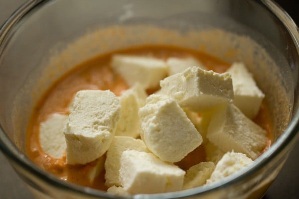 adding paneer cheese to the marinade.