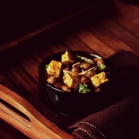 chole paneer served in a black bowl