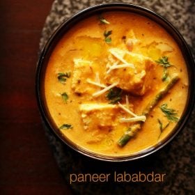 paneer lababdar in a black bowl with ginger julienne on top