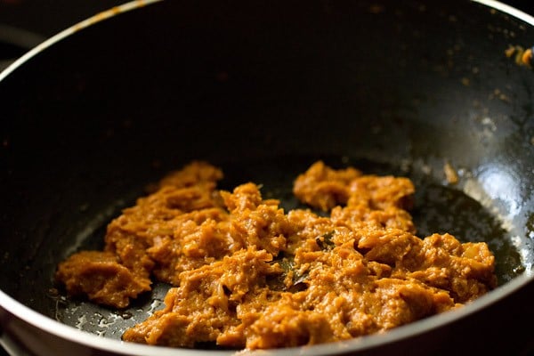 sautéing the masala paste with oil being released at the sides