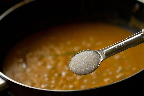 salt being added with a measuring spoon