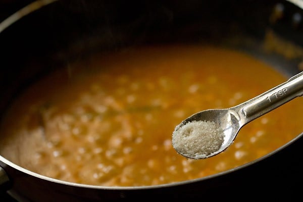 sugar being added with a measuring spoon