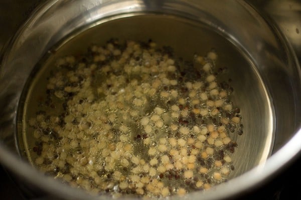 mustard seeds and urad dal added to hot oil in pan. 