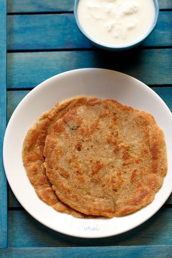 rajgira paratha served on a white plate with raita