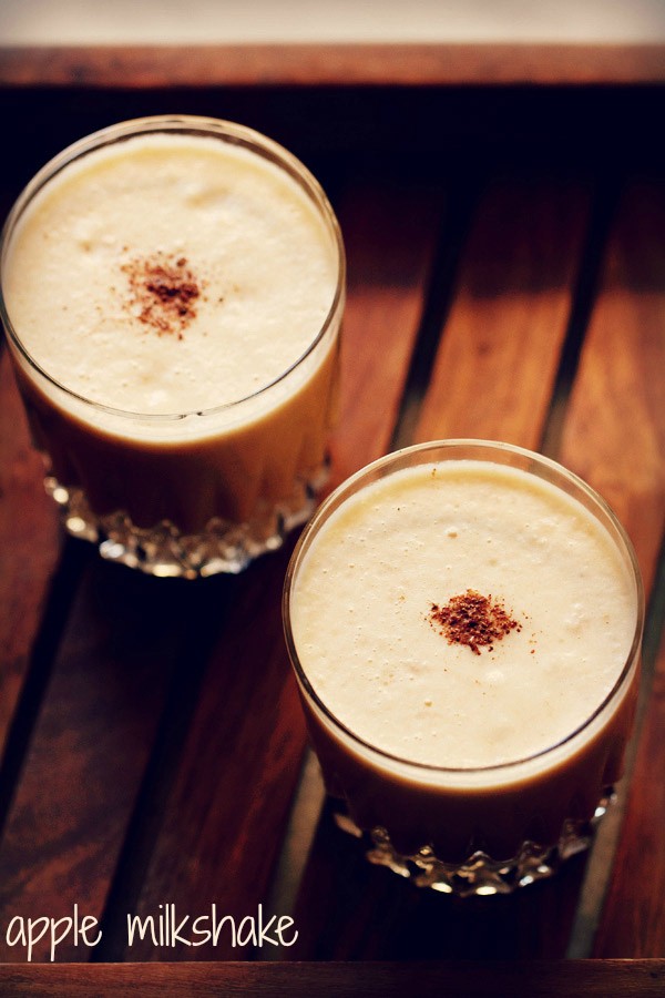 apple milkshake garnished with cinnamon powder and served in 2 glasses.