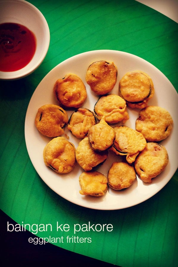 brinjal pakora or brinjal bajji on a white plate with a side of chutney at the side