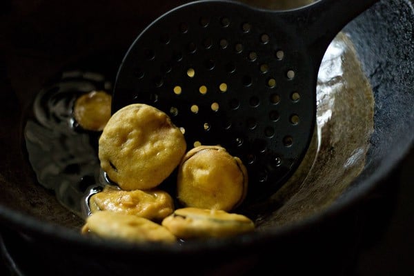 removing fried brinjal pakora With a slotted spoon