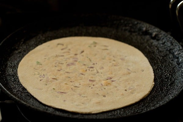 cooking cheese paratha on skillet