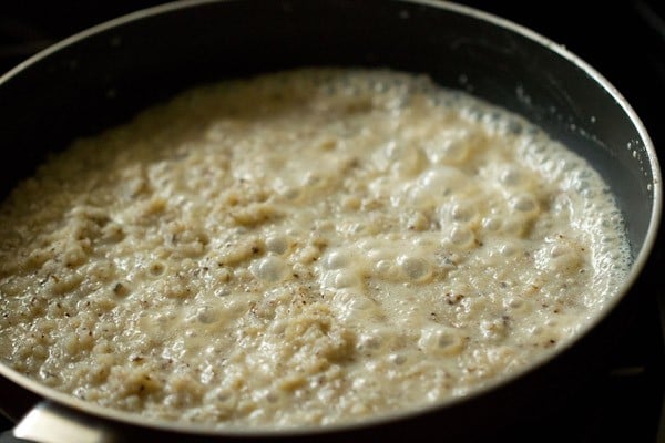 simmering coconut ladoo mixture in pan