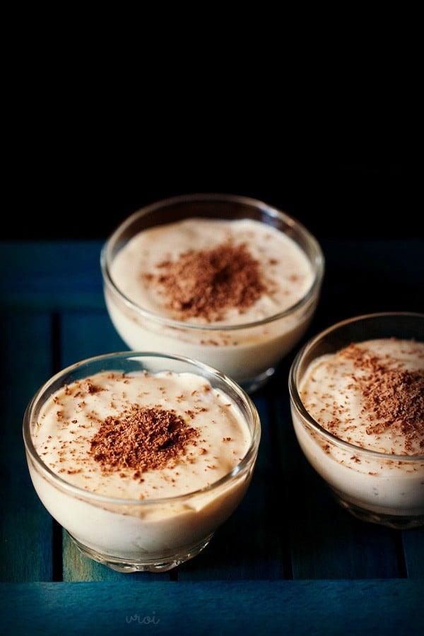 eggless banana mousse served in glass bowls, garnished with grated chocolate. 