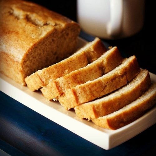 applesauce cake loaf with slices on white tray