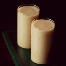 guava juice in two glasses on a dark green wooden tray