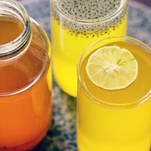 bebida de calabaza con limón servida en vasos con un frasco de jarabe de calabaza con limón al lado