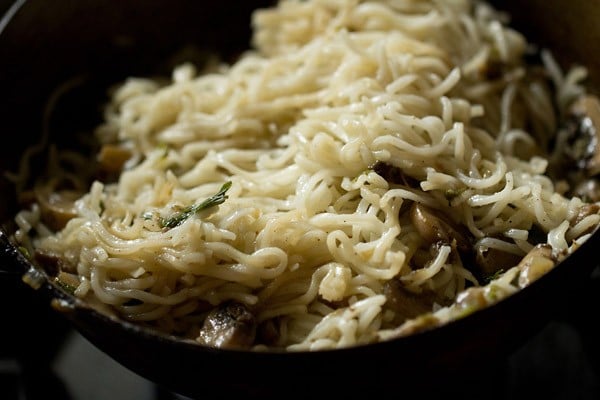 adding noodles to the pan with veggies