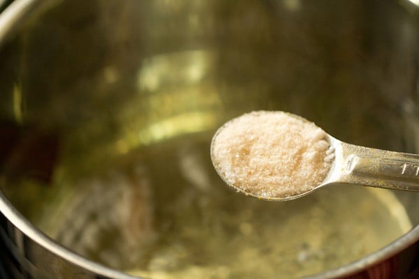 salt being added with a measuring spoon