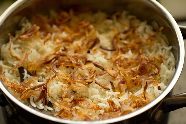 cebolas fritas em camadas no topo da camada de arroz