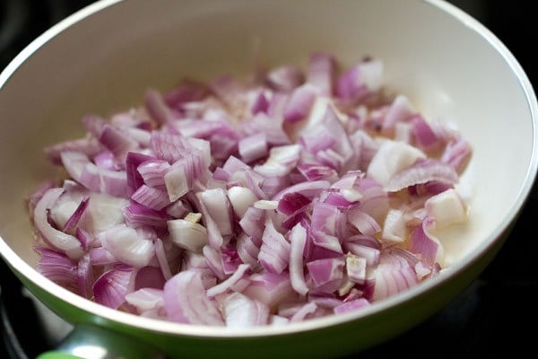 onions in a pan for making fried onion paste for paneer pasanda recipe