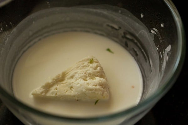 paneer sandwich being dipped in cornstarch mixture for paneer pasanda