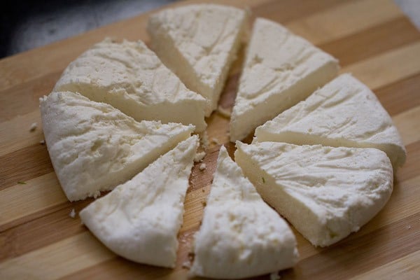 paneer wedges separated on a wooden cutting board