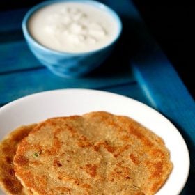 rajgira paratha served on a white plate with raita.