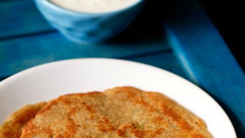 rajgira paratha served on a white plate with raita.