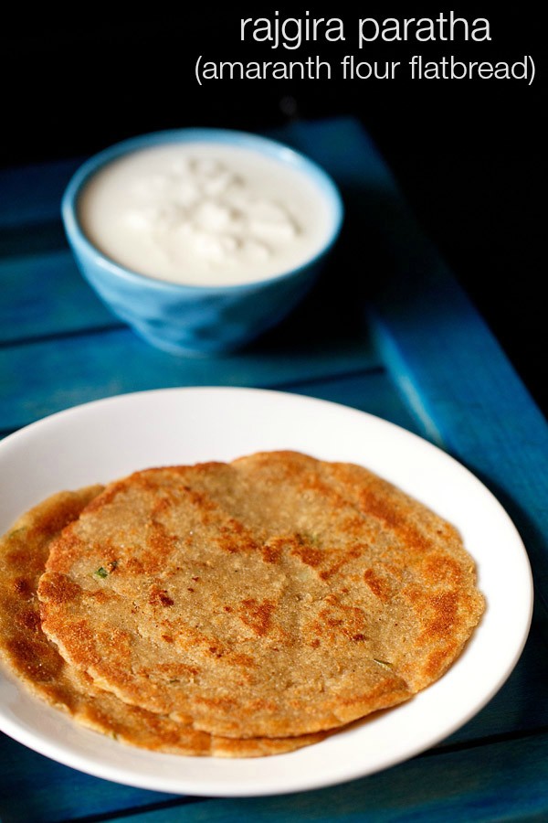 rajgira paratha served on a white plate with raita.