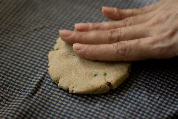 flattening rajgira paratha dough ball with hands
