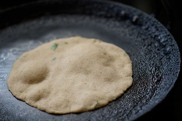 frying amaranth paratha on tawa