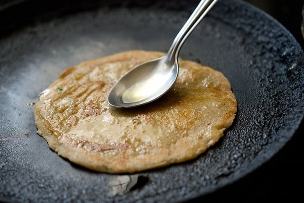 frying and applying oil on rajgira paratha