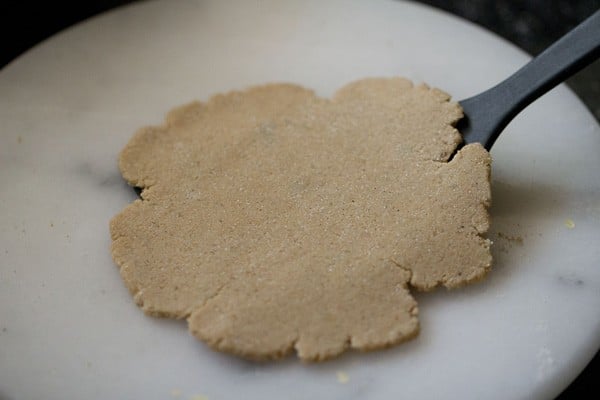 lifting rolled rajgira paratha with a spatula