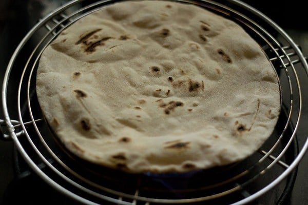 opposite side of the butter roti looks more evenly charred and blistered.
