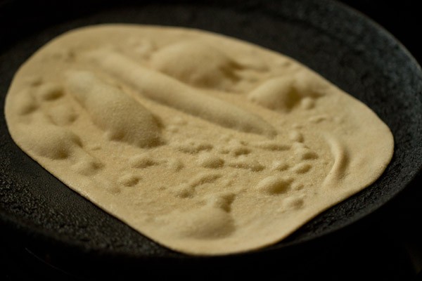 making tandoori roti on the tawa - it is getting large bubbles after being placed on the flame.