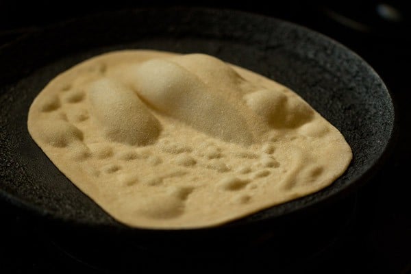 making tandoori roti on the stovetop - the air-pockets are getting bigger and the dough looks drier.