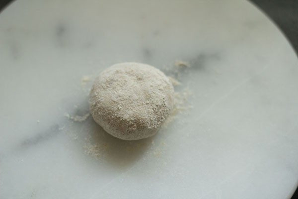 dough ball that is lightly flattened and floured for making tandoori roti.