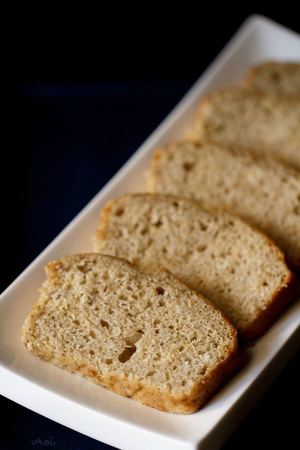 vegan applesauce sponge cake cut into slices and displayed on a white rectangular plate.