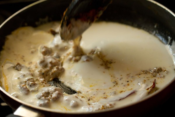 stirring curd and achari masala